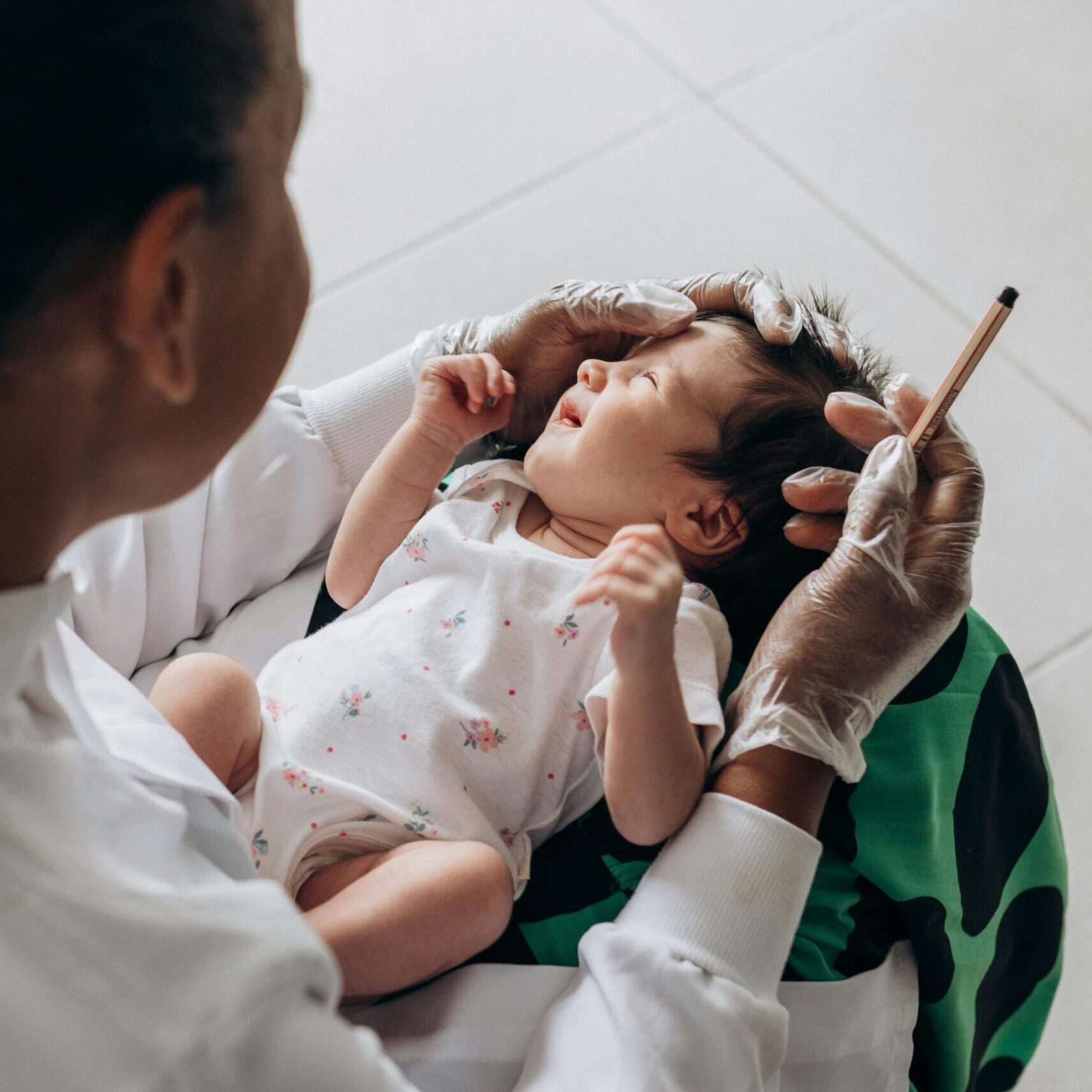 A medical professional examines a newborn baby indoors, highlighting healthcare and care.