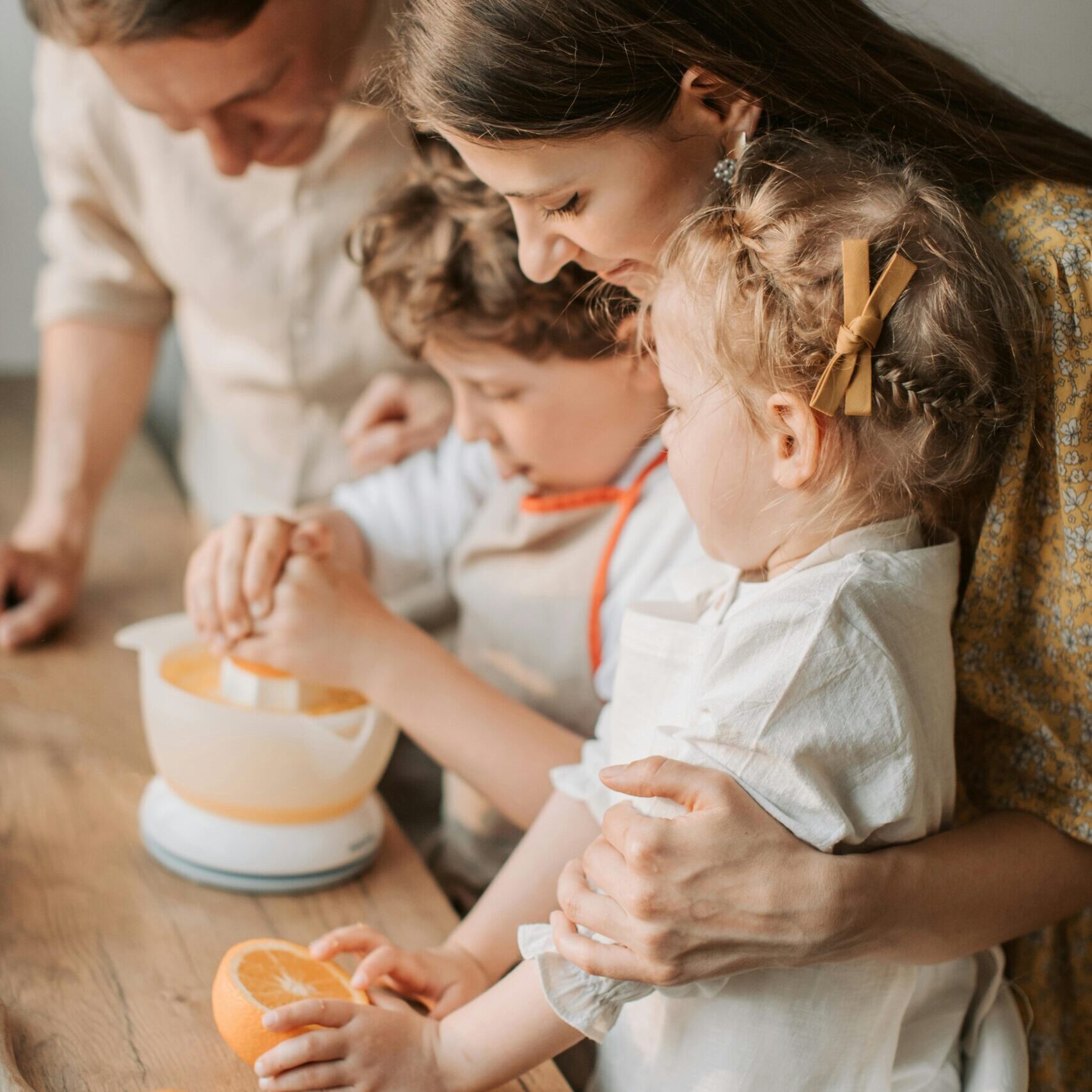 Family bonding while making fresh orange juice together in the kitchen. A moment of joy and togetherness.