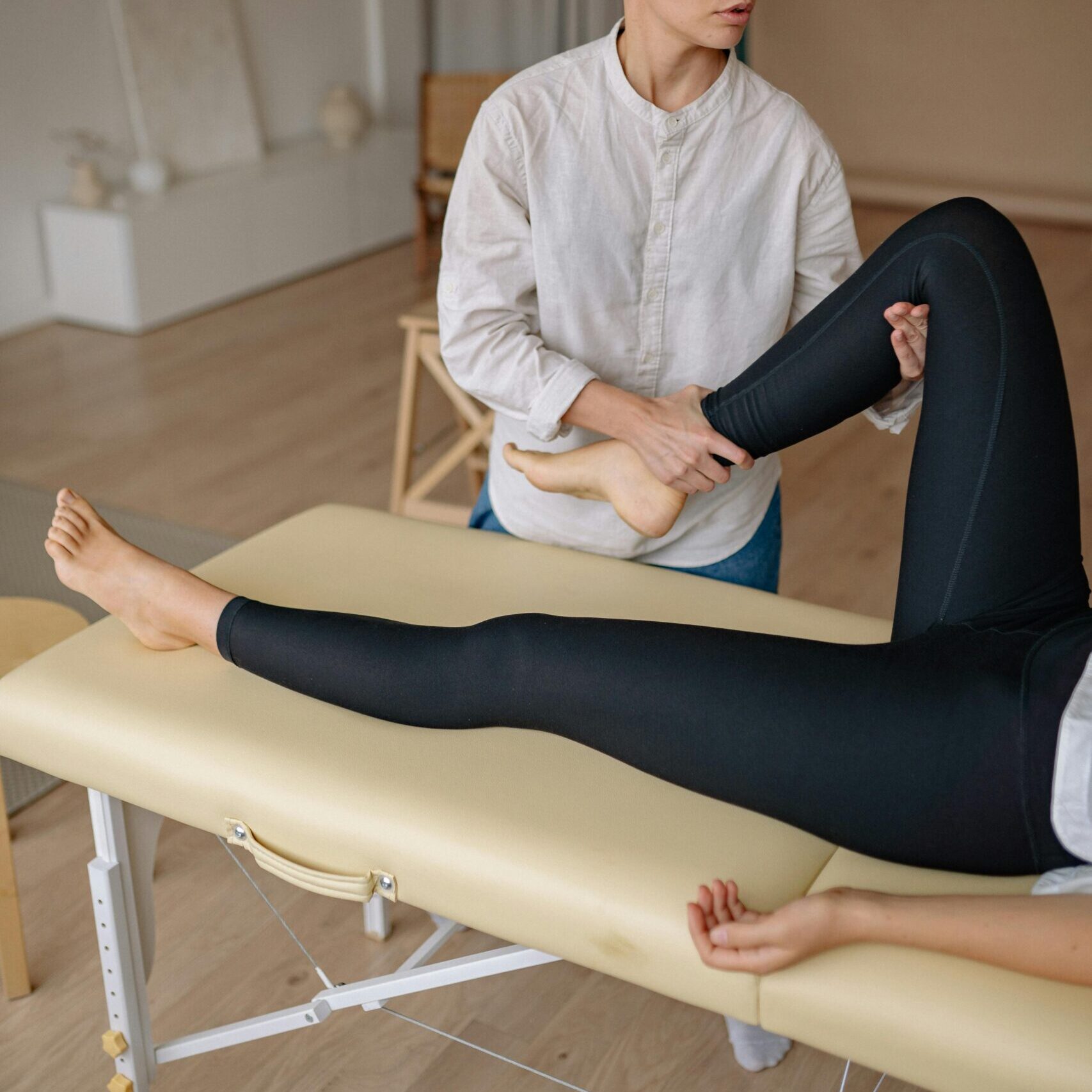 Woman receiving a leg massage in a serene spa environment, promoting relaxation and wellness.