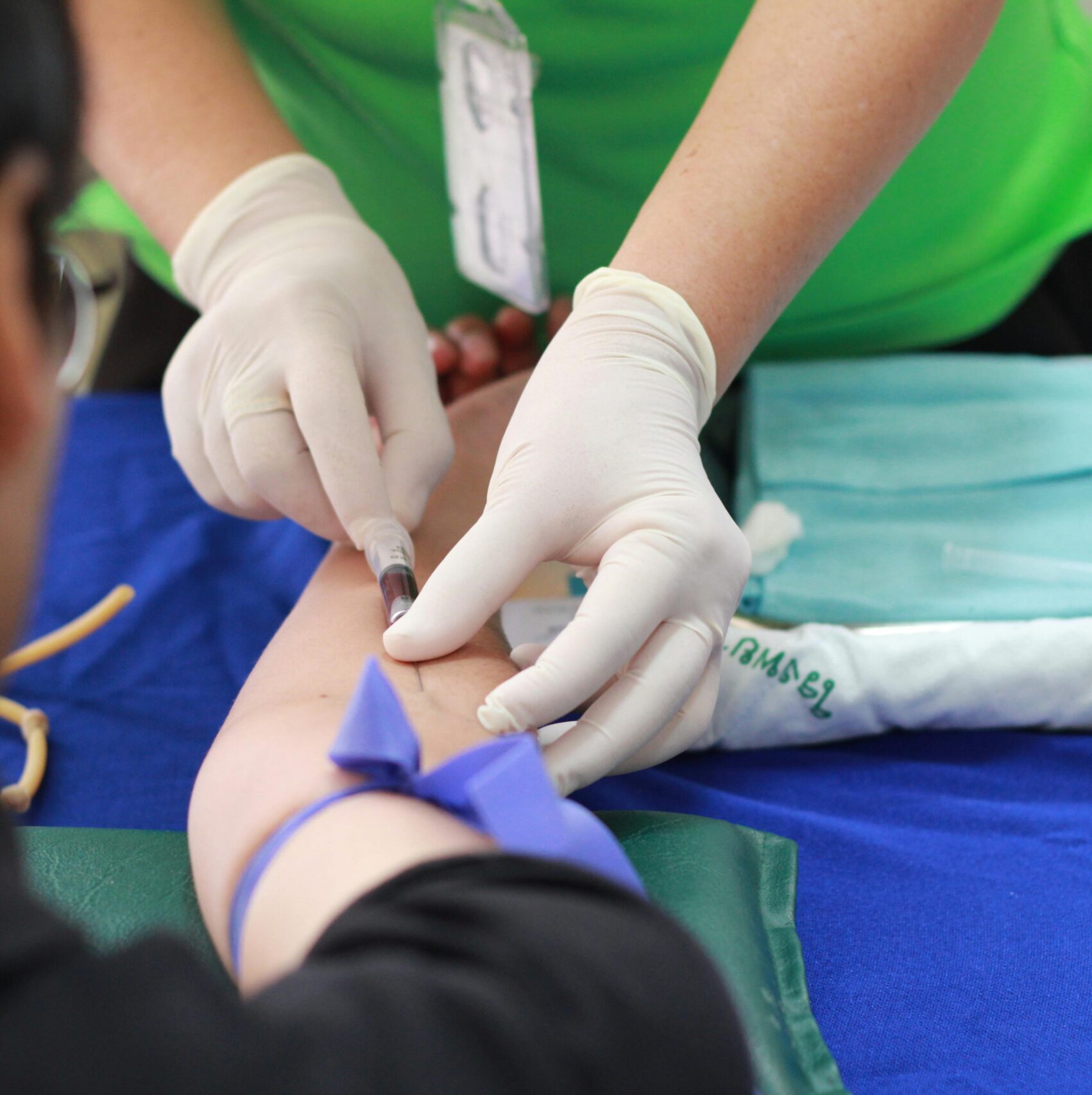 A healthcare professional administering an injection to a patient's arm during a medical procedure.