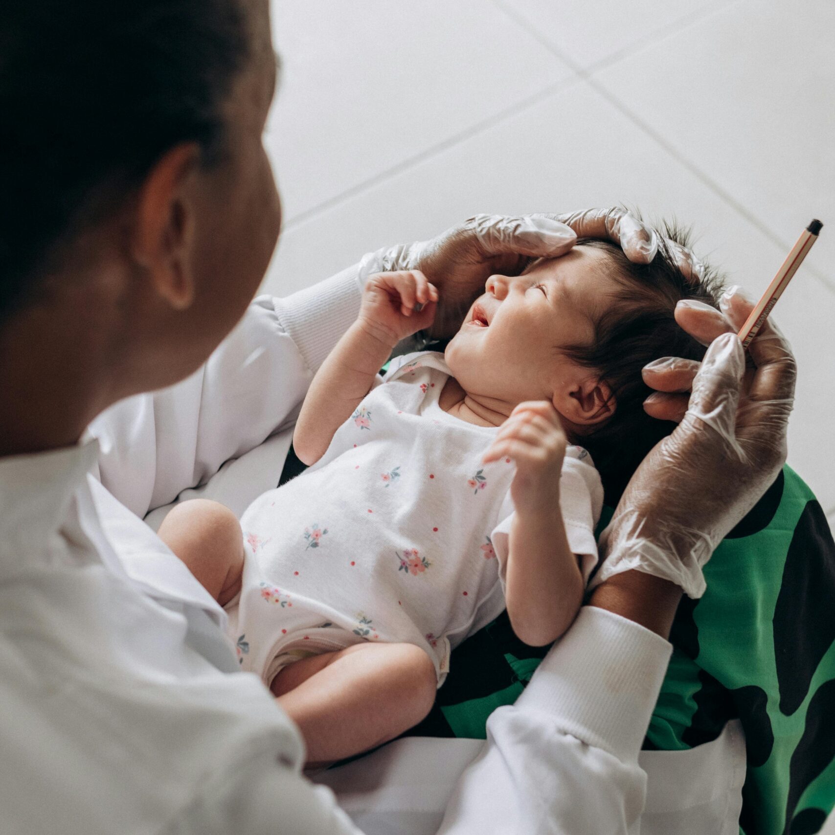 A medical professional examines a newborn baby indoors, highlighting healthcare and care.