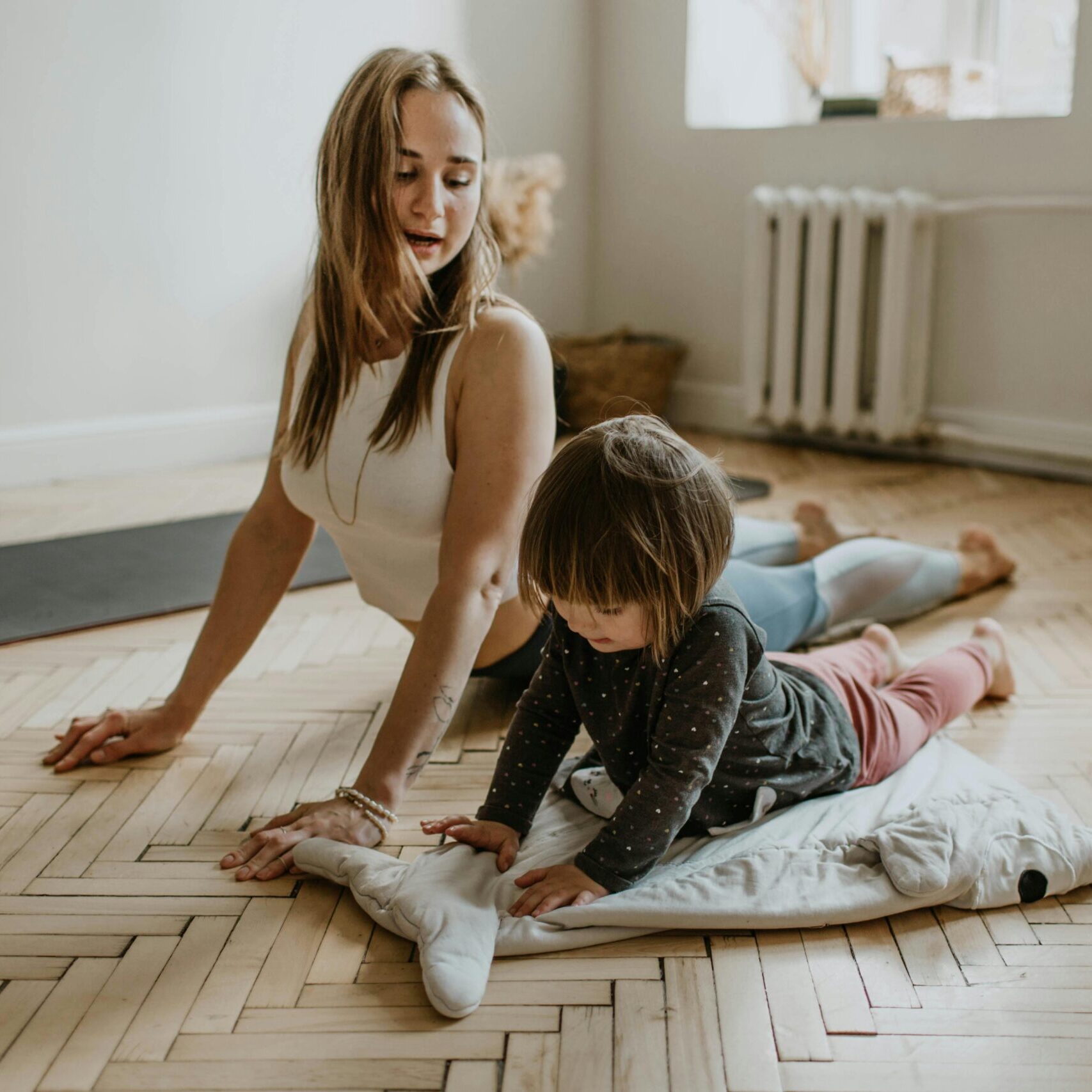 A mother and child practicing yoga together at home on a sunny day, fostering wellness and connection.