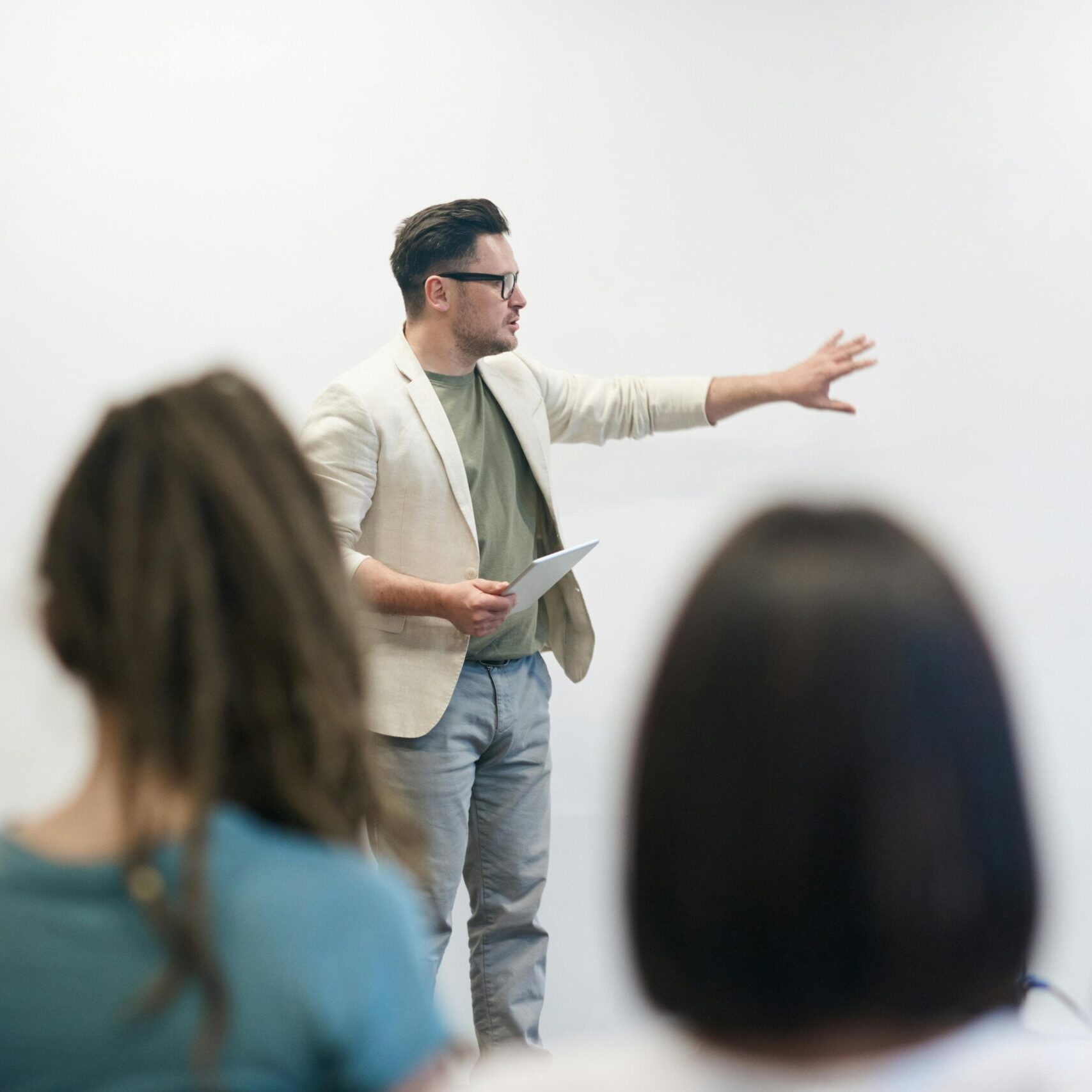 A man in a blazer gives a presentation to a captivated audience in a lecture setting.