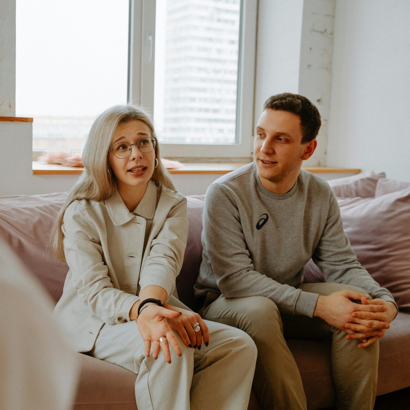 A couple and therapist engaged in a discussion during a therapy session indoors.