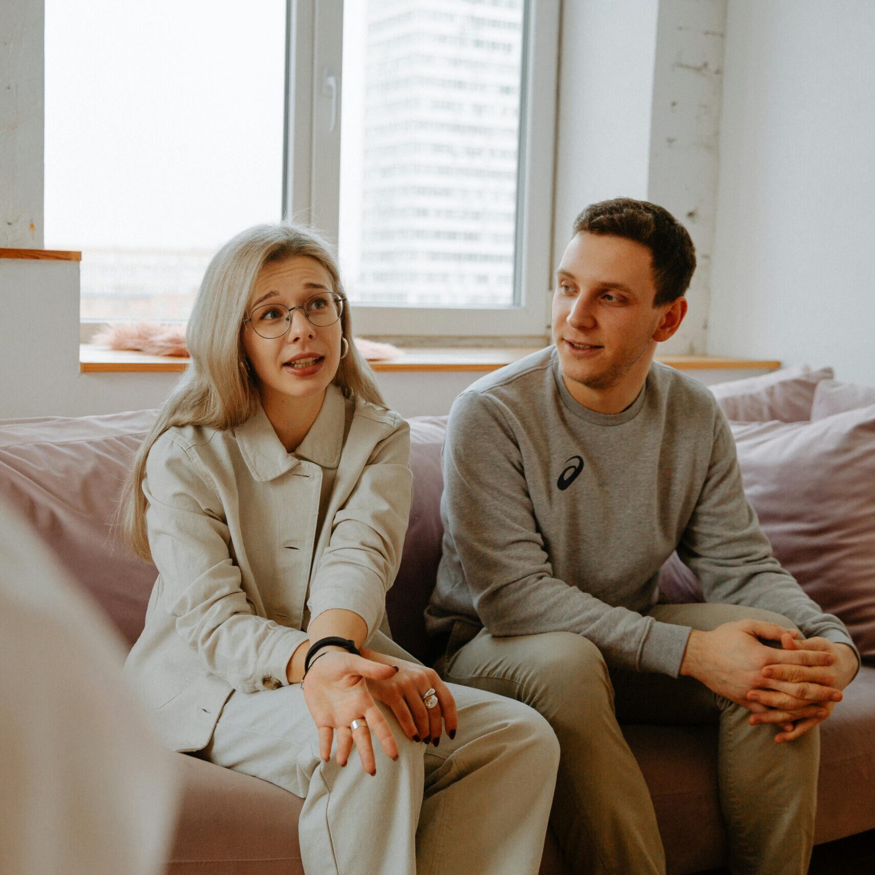 A couple and therapist engaged in a discussion during a therapy session indoors.