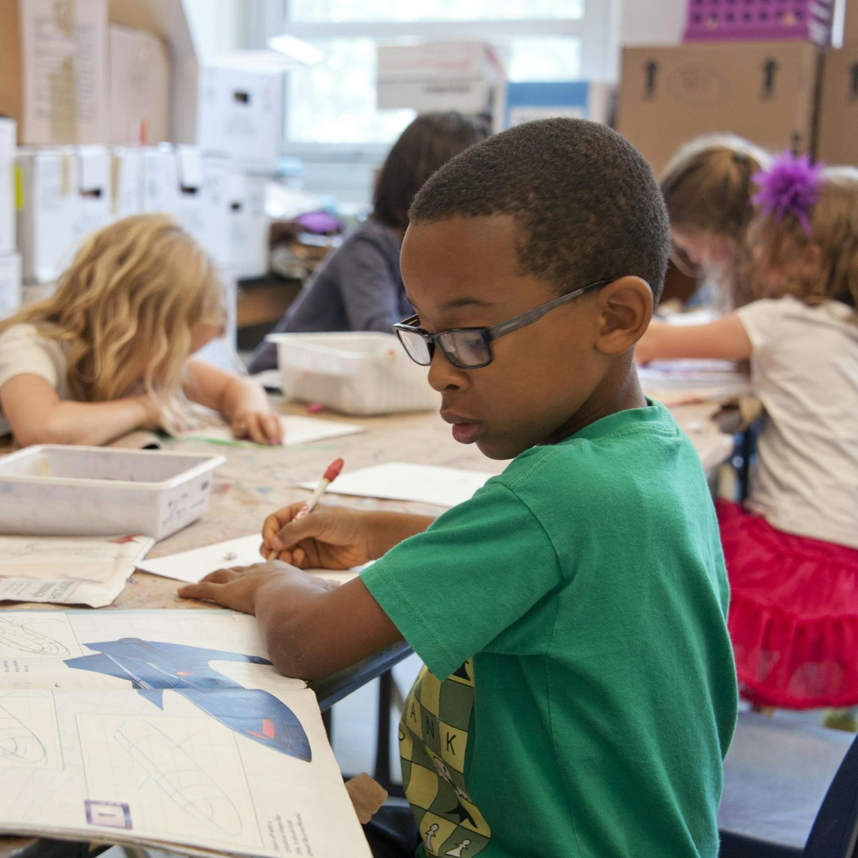 Group of children focused on educational activities in a classroom setting.