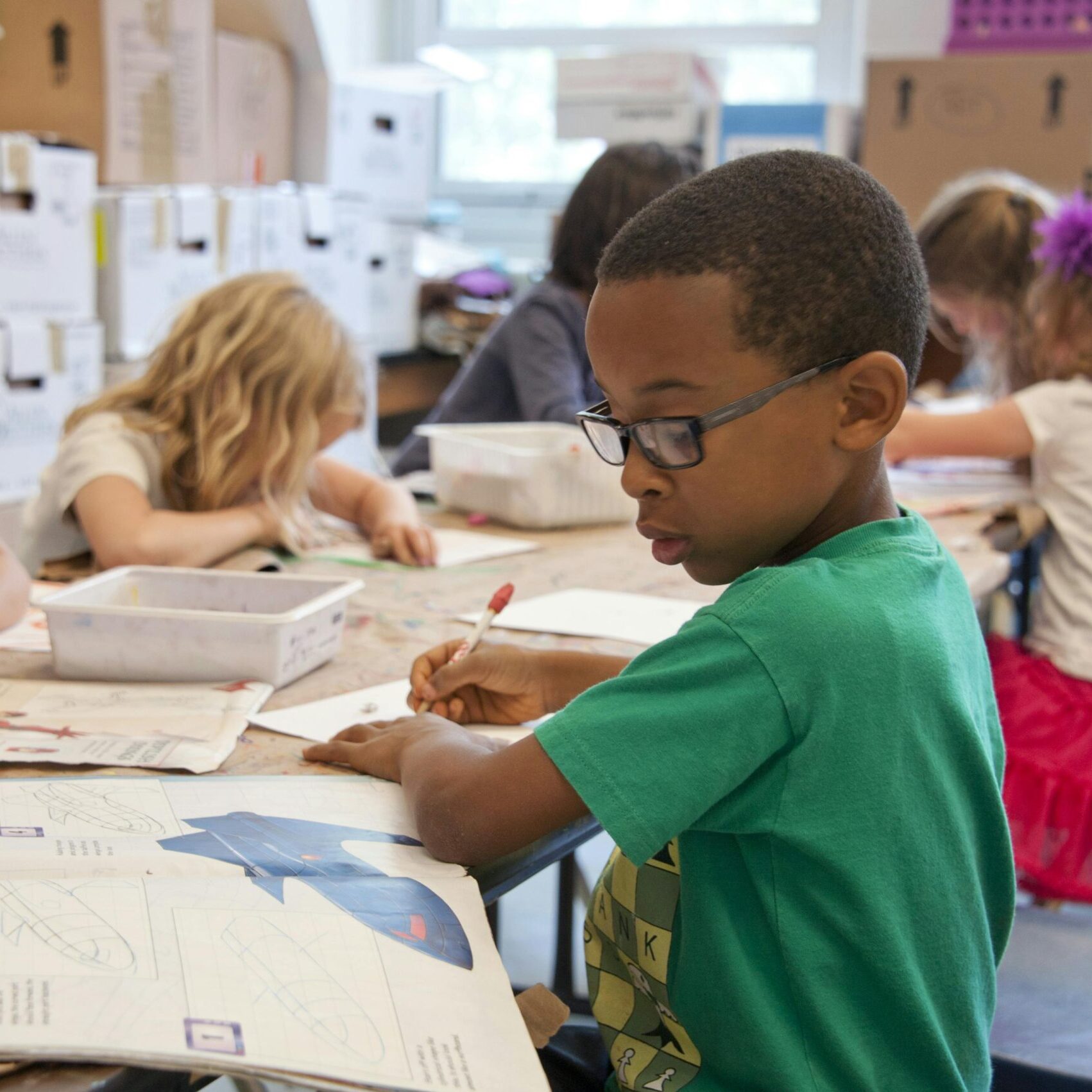 Group of children focused on educational activities in a classroom setting.