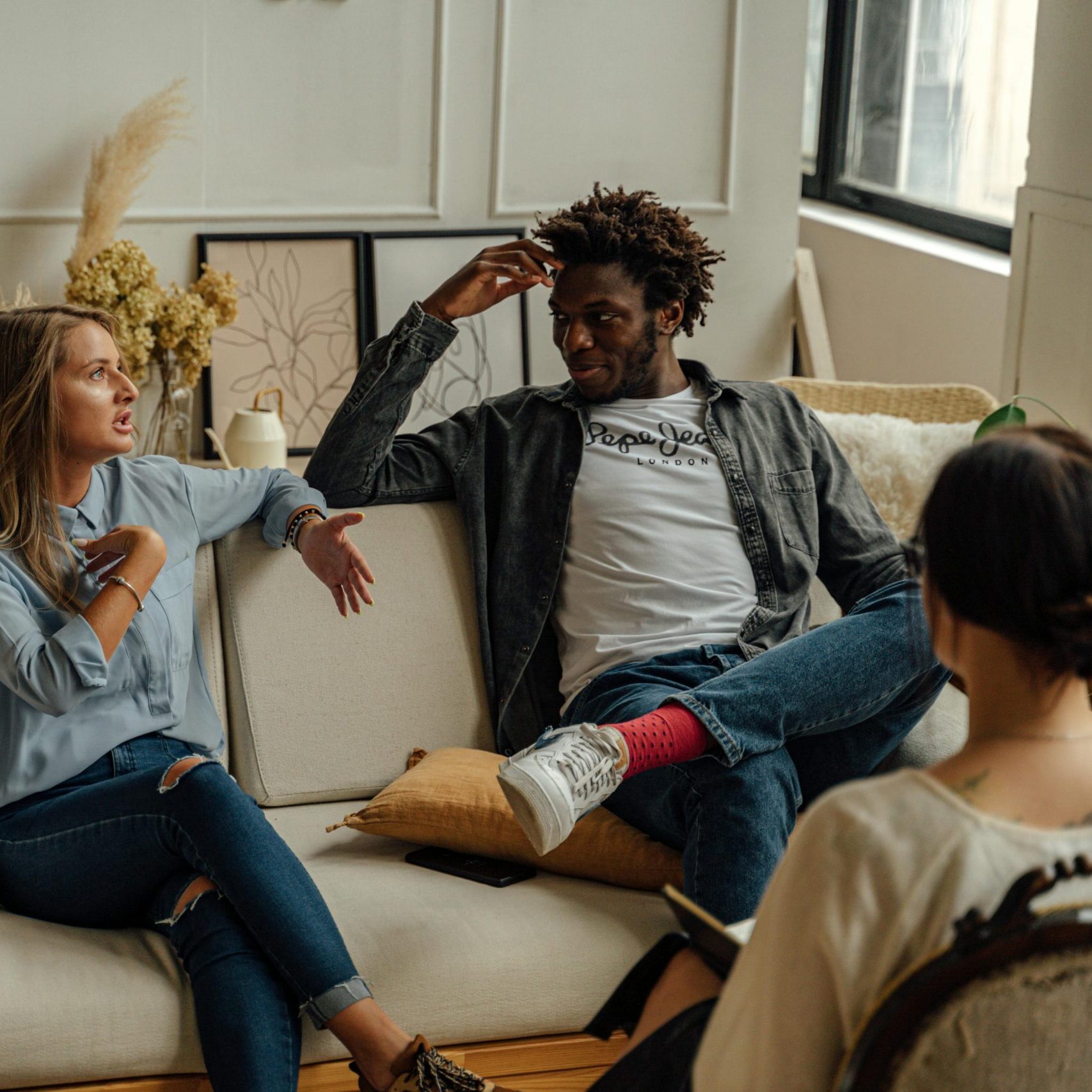 A couple is engaged in a lively conversation during a therapy session with a counselor.