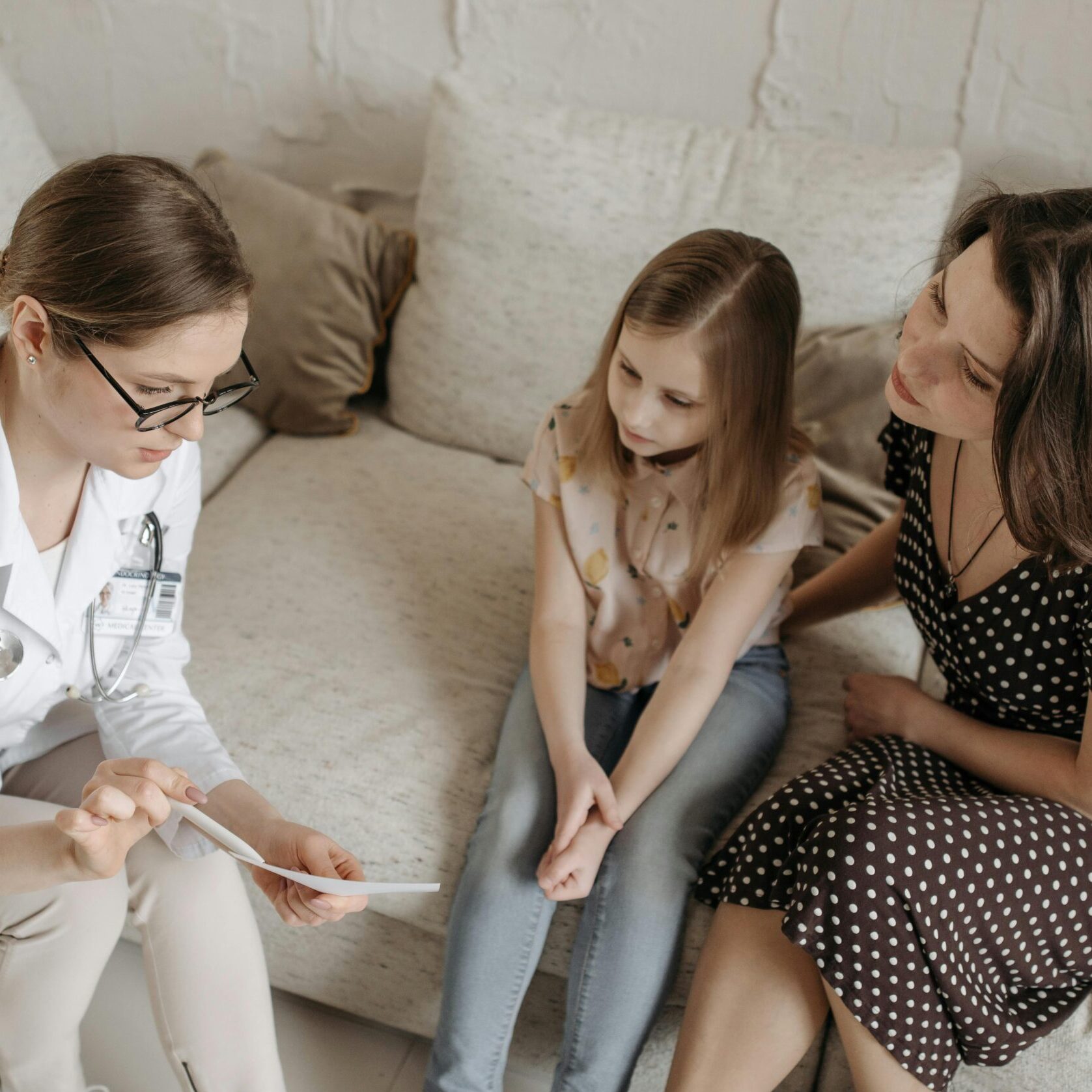 Doctor explaining diagnosis to mother and daughter in office.